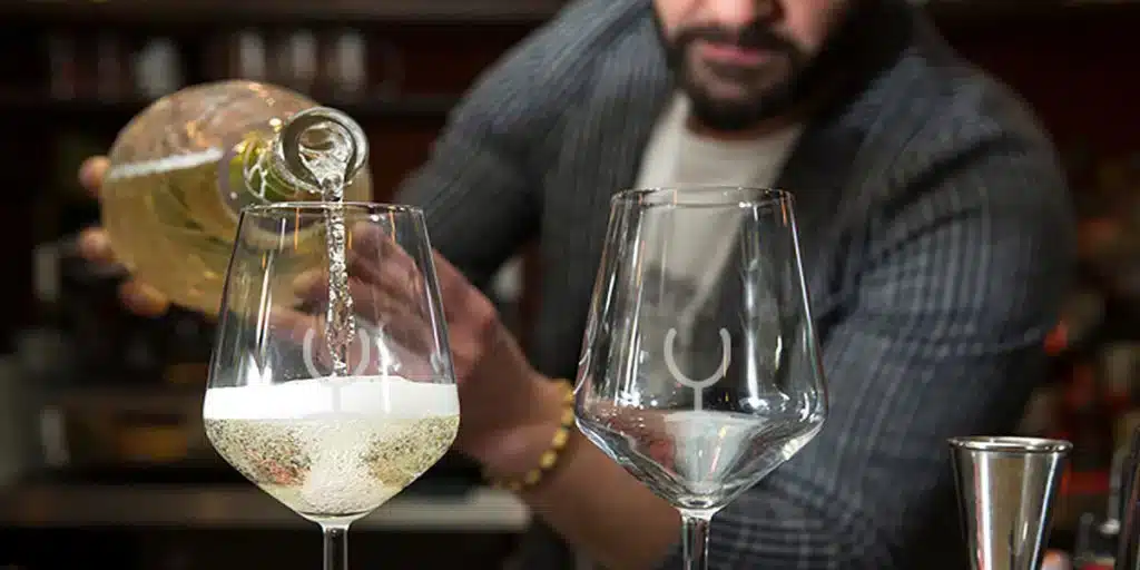 Gegraveerde wijnglazen - Man die wijnglazen inschenkt